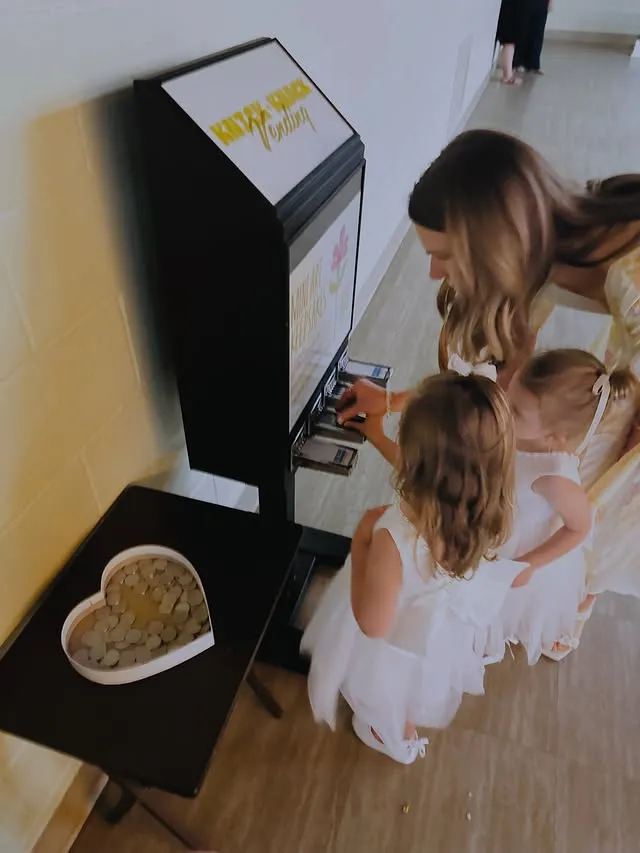 Flower girls at the machine with a heart-shaped bowl of tokens